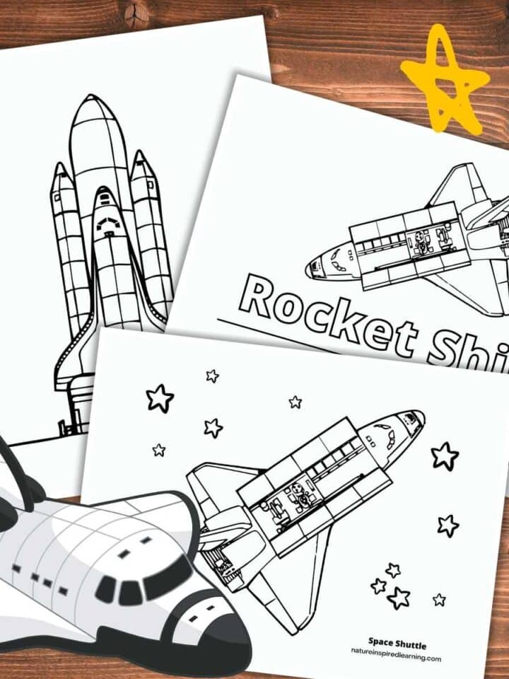 Three rocket coloring pages overlapping on a wooden background three yellow stars upper right and flying rocket ship bottom left.