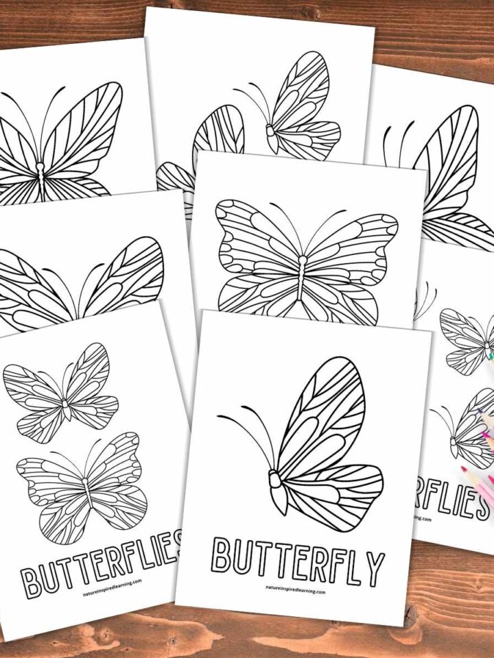 collection of coloring pages with butterfly designs overlapping each other on a wooden background colored pencils bottom right