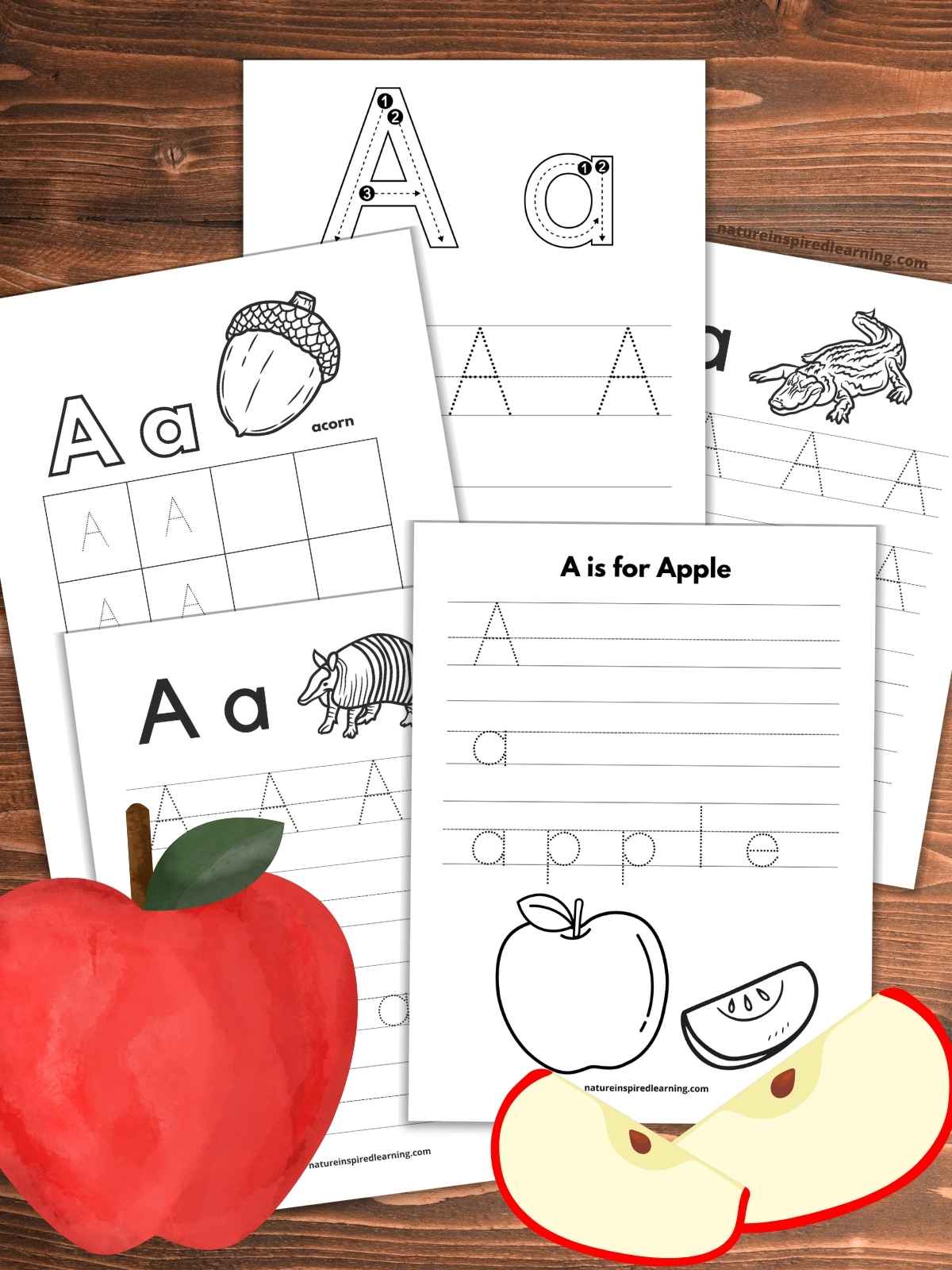 Tracing Letter A worksheets overlapping each other on a wooden background with a large red apple bottom left and two apple slices bottom right