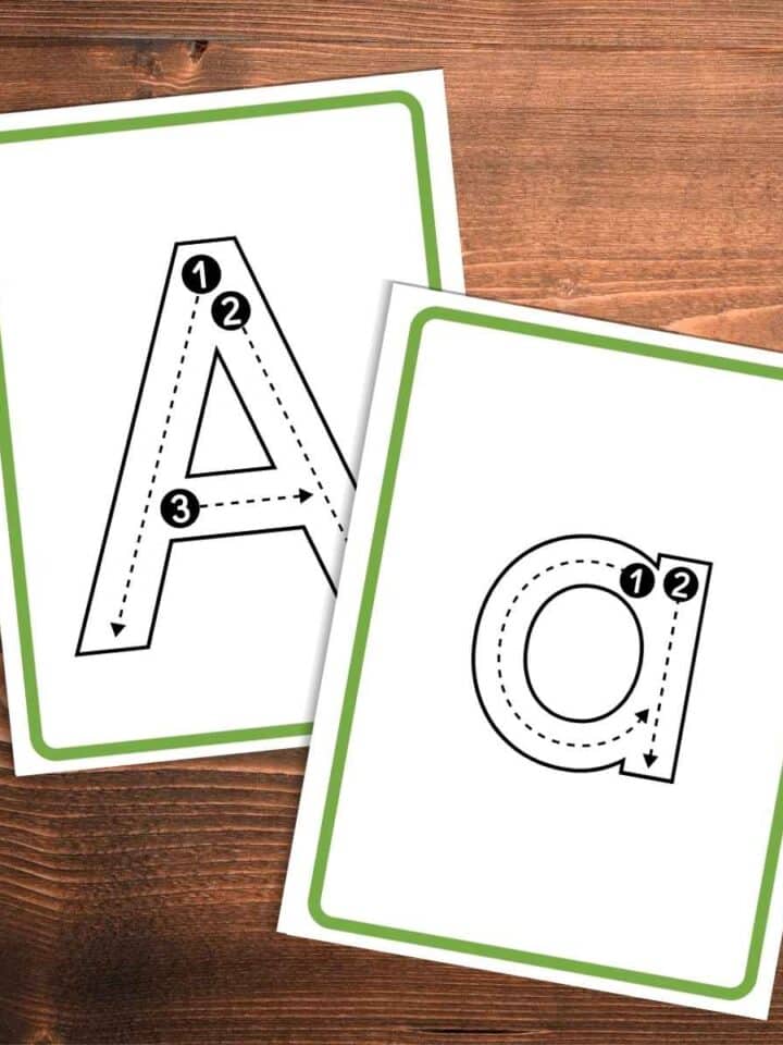 Capital letter A with guide lines and numbers for tracing on a card with a simple green outline under a lowercase letter a tracing card with guidelines and numbers with a simple green outline. Both printable cards on a wooden background