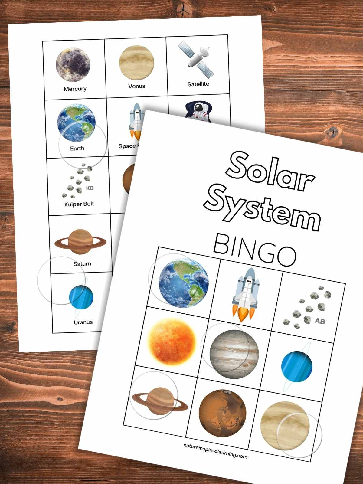 colorful solar system bingo card overlapping calling cards with images and labels on a wooden background with clear plastic circles on both printables