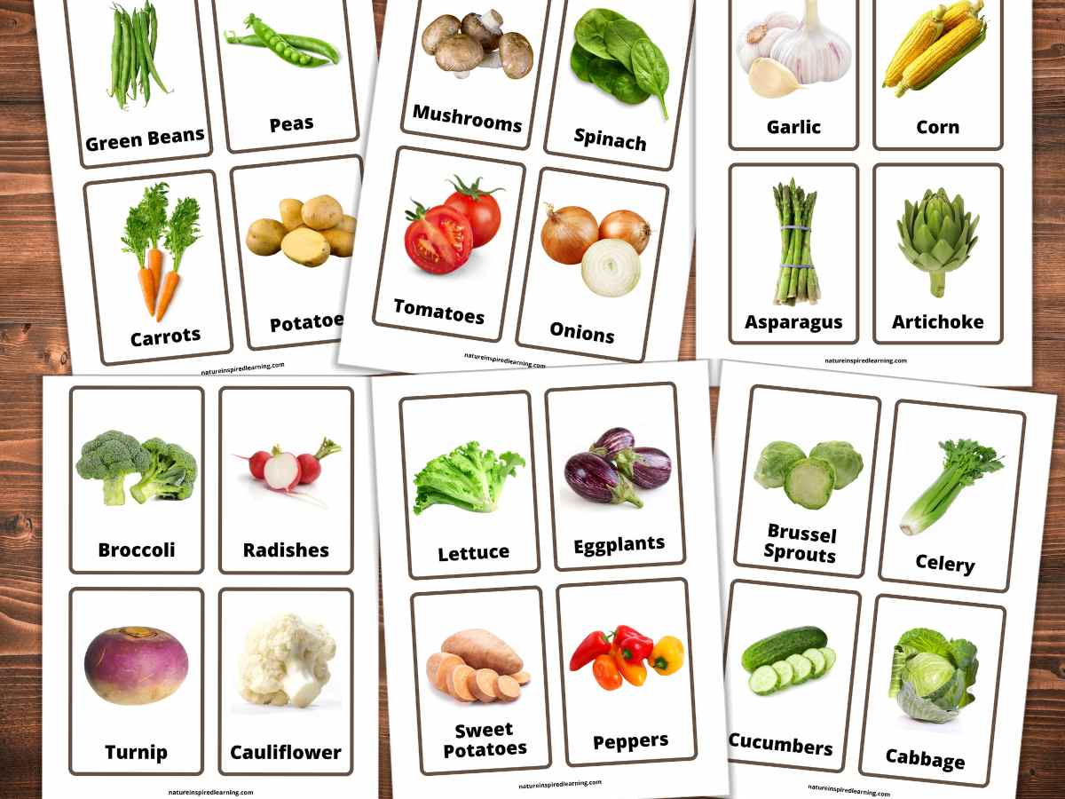 collection of printable flashcards overlapping each other with colorful images of each vegetable and a label all on a wooden background