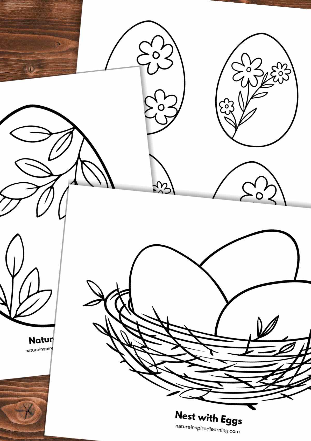 three black and white sheets with different egg designs including a large egg with leaf designs, eggs with flowers, and a nest with three eggs overlapping each other on a wooden background.