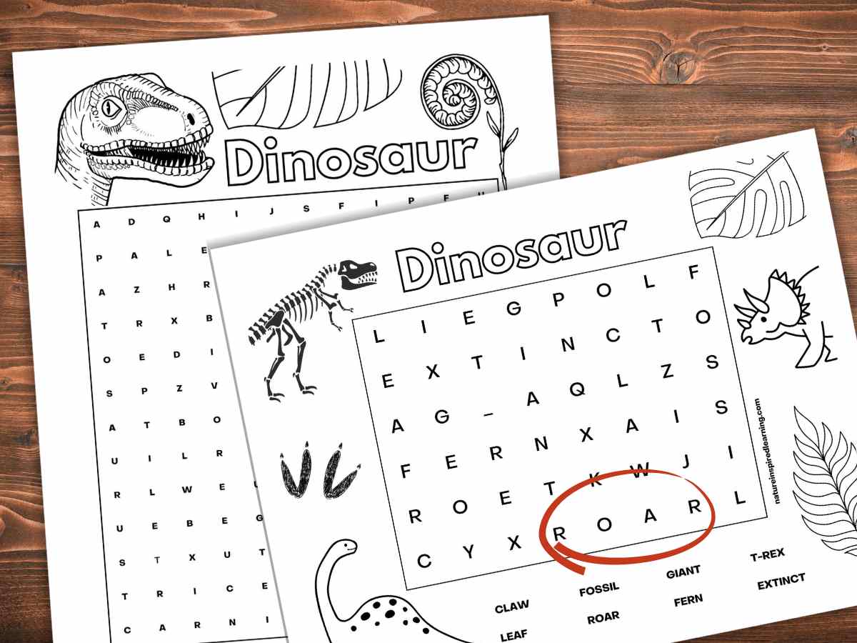 Two black and white dinosaur word searches one easy one difficult overlapping on a wooden background. Roar circled in red.